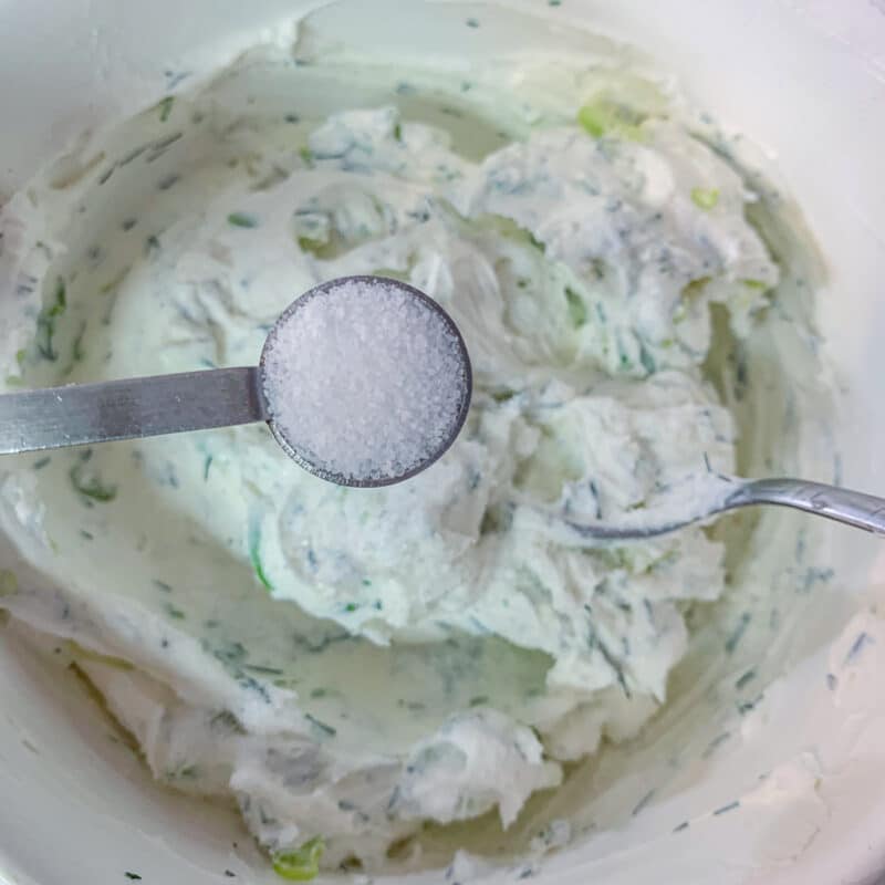 salt being added to greek yogurt cream cheese