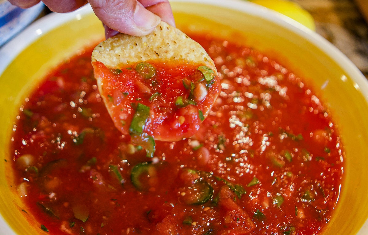 dipping a chip into Mexican salsa bowl