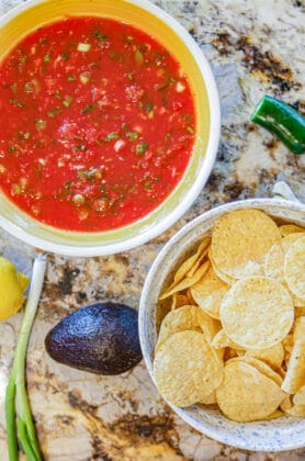 red salsa and chips, avocados, scallion and lemon on the side