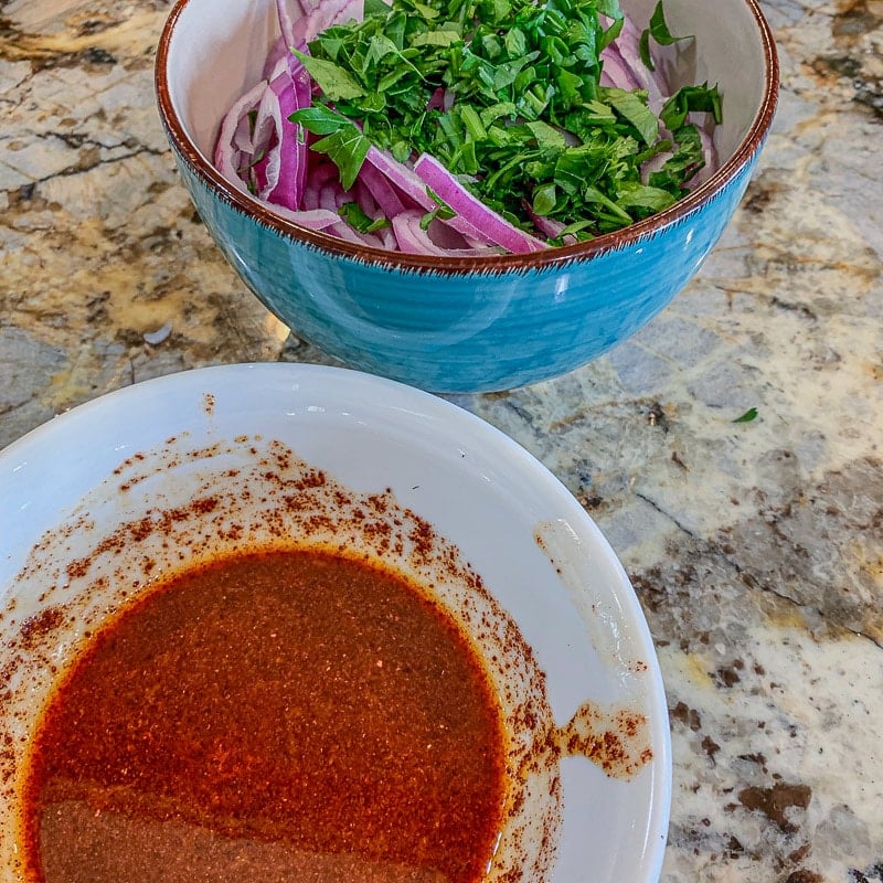 onions and parsley in a bowl with dressing on the side