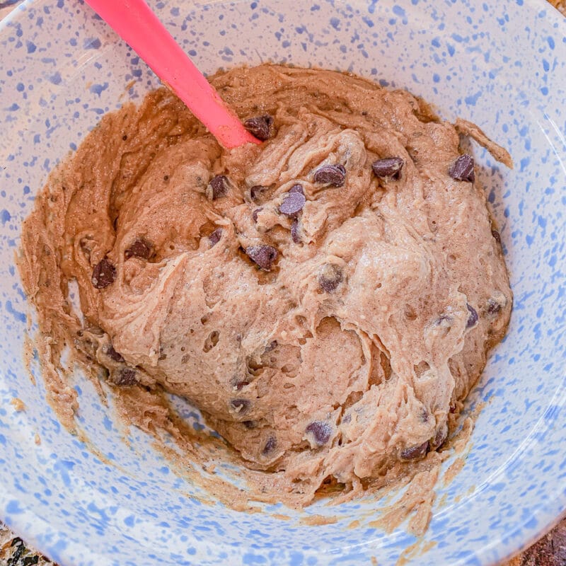 chickpea cookie dough in a light blue bowl with a pink spatula