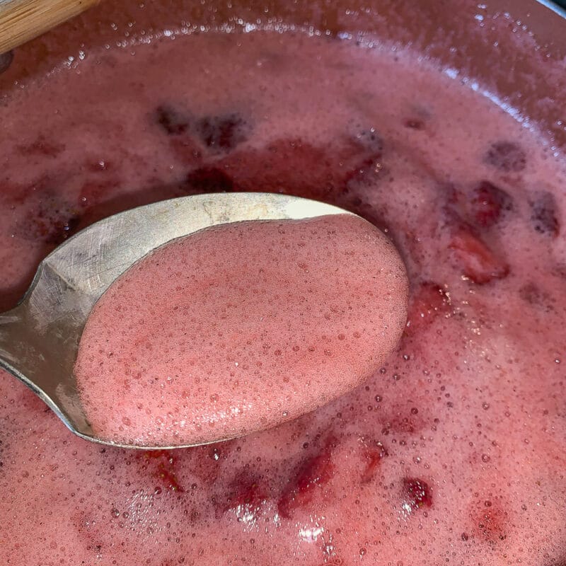 skimming foam off of strawberry jam