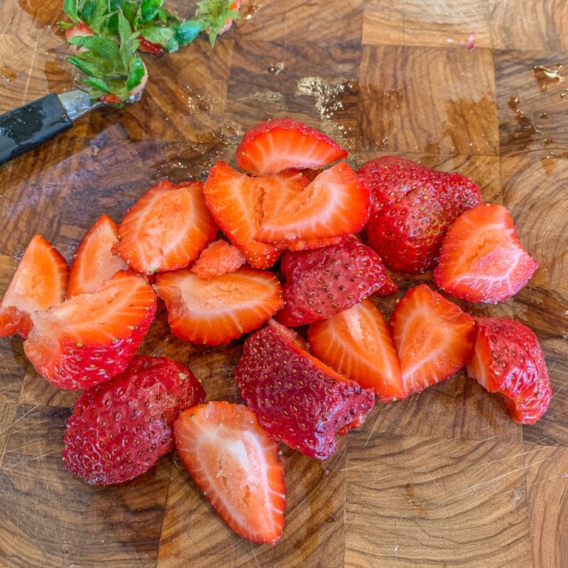 chopped strawberries on a cutting board