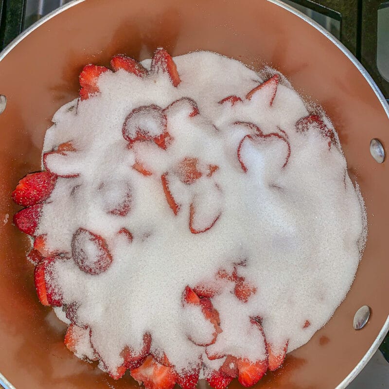 strawberries covered with sugar in a brown pot
