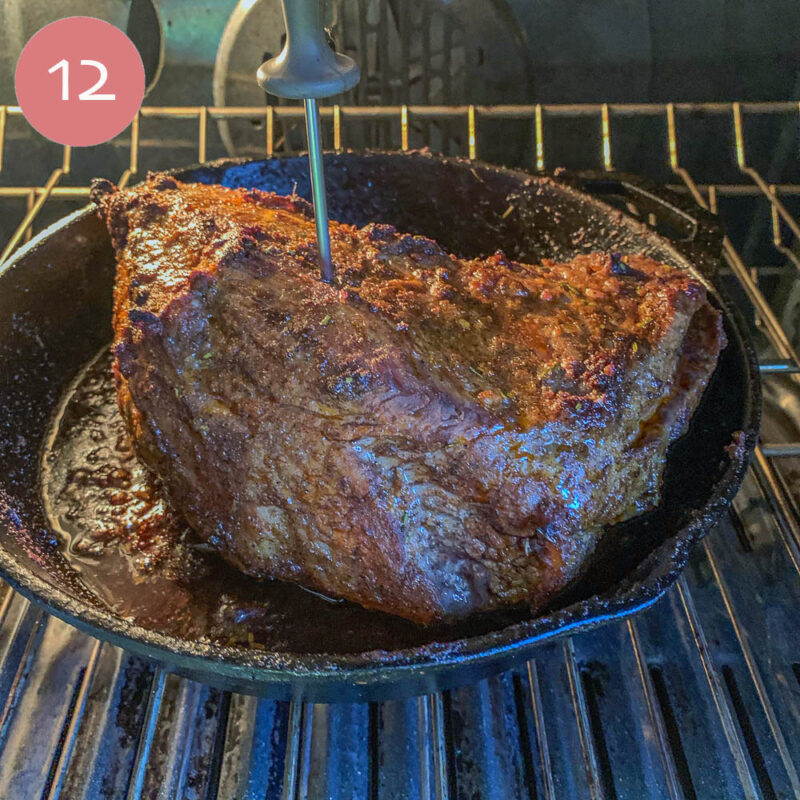 tri-tip being cooked in a cast iron pan in the oven