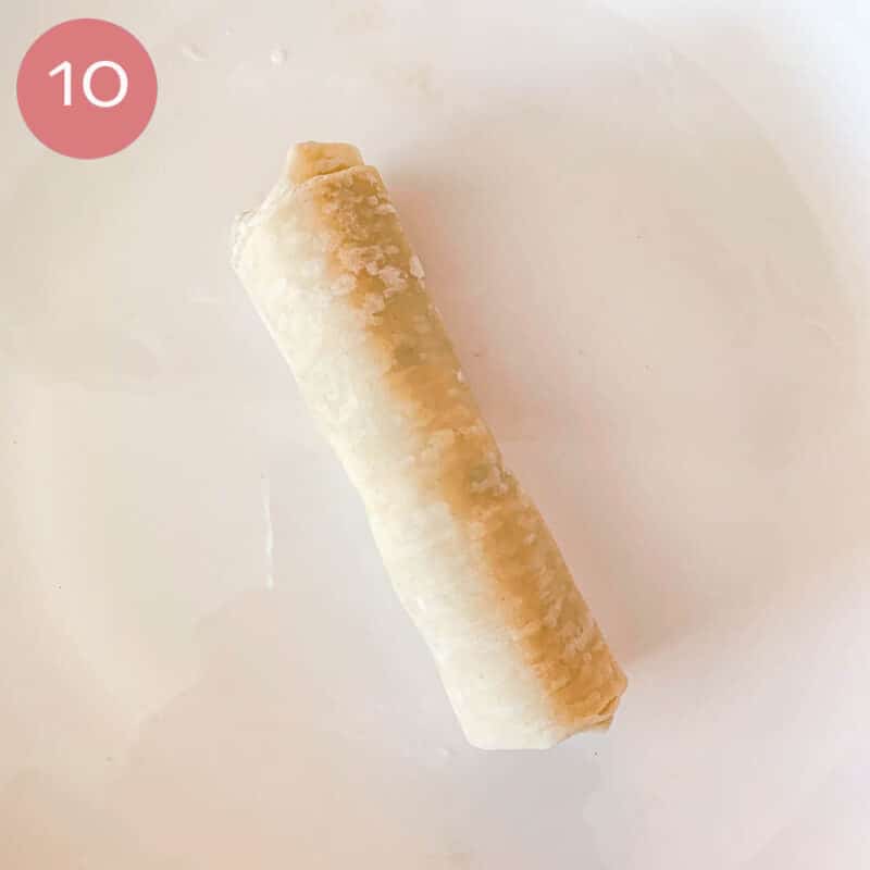 untried egg roll on a white plate