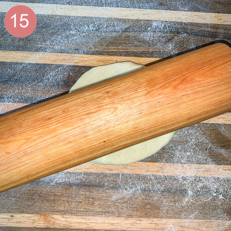 a rolling pin on top of some bread dough on a floured cutting board