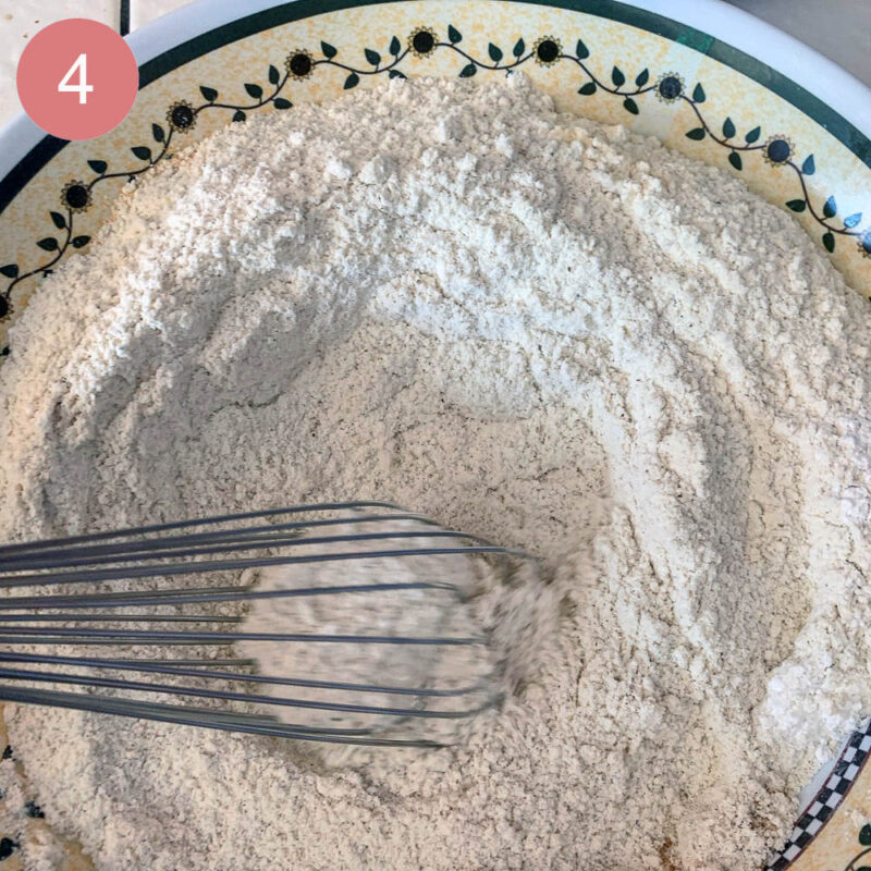 flour and spices being whisked in a a bowl