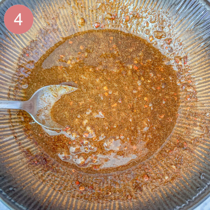 marinade in a brown bowl being stirred with a  spoon