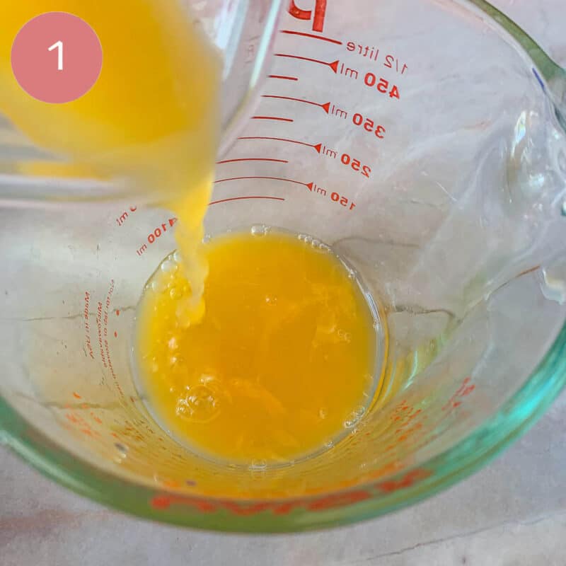 pouring orange juice into a measuring cup