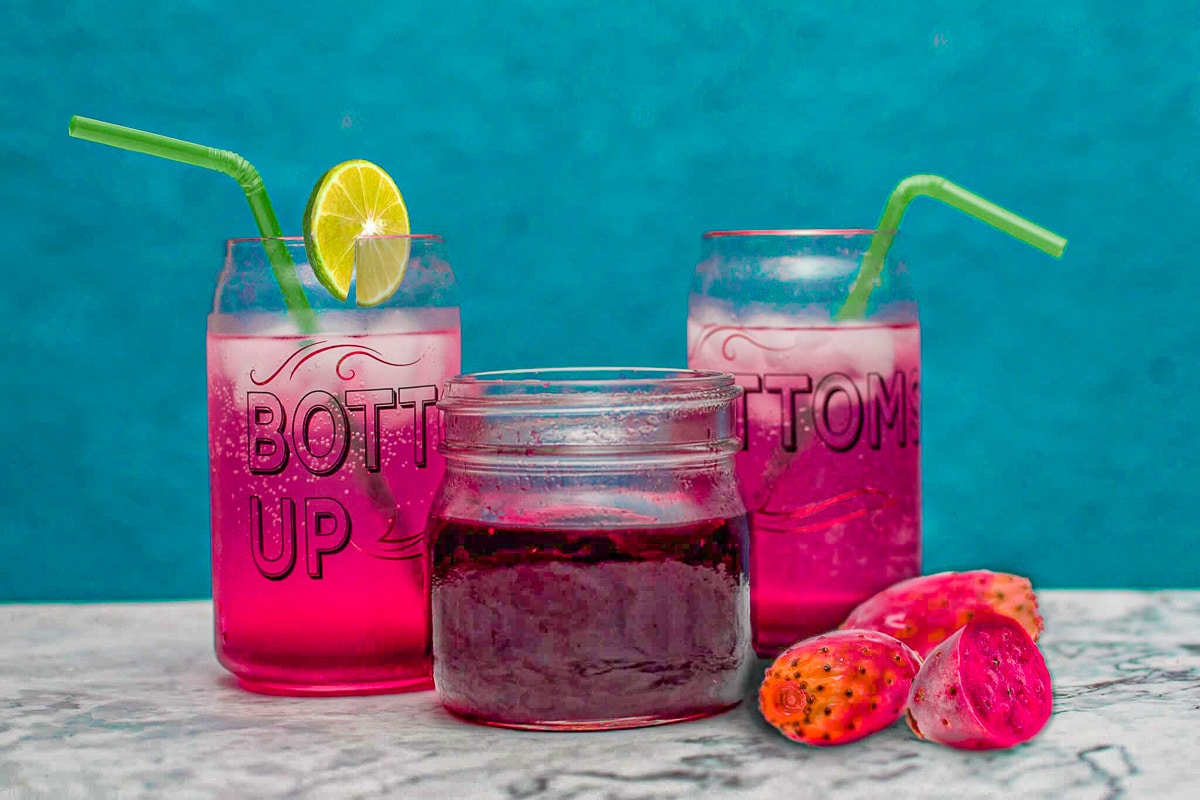 prickly pear juice in two glasses with some syrup and prickly pears