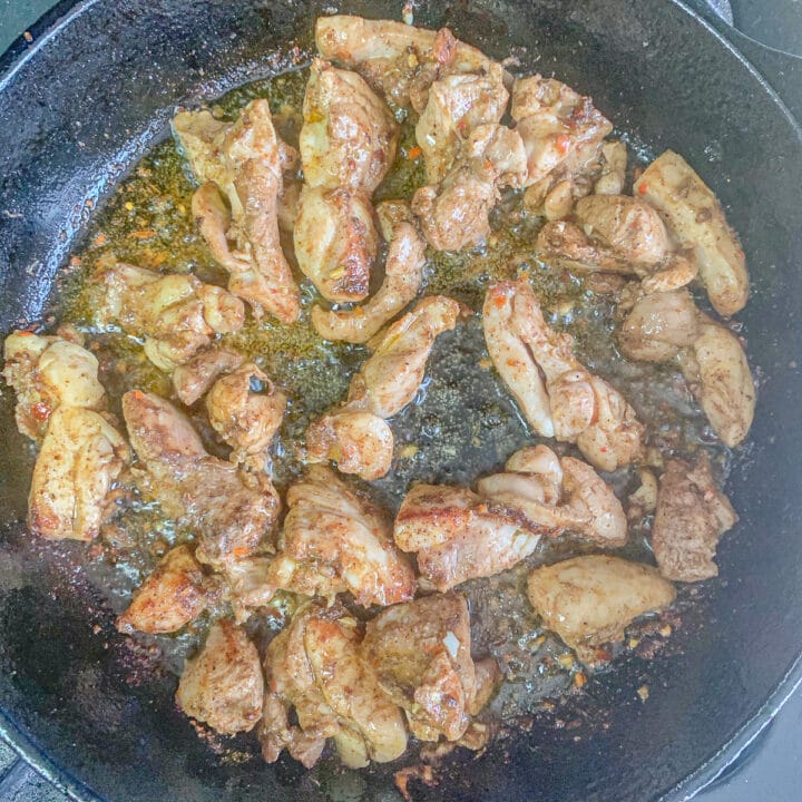 shawarma chicken being cooked in a cast iron pan