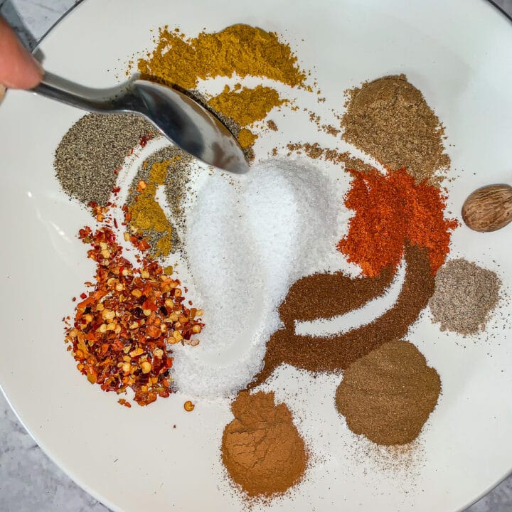 swirling spices together with a spoon on a white plate