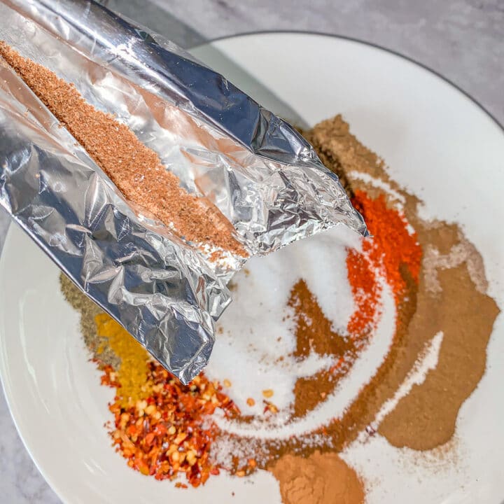pouring nutmeg over a plateful of spices