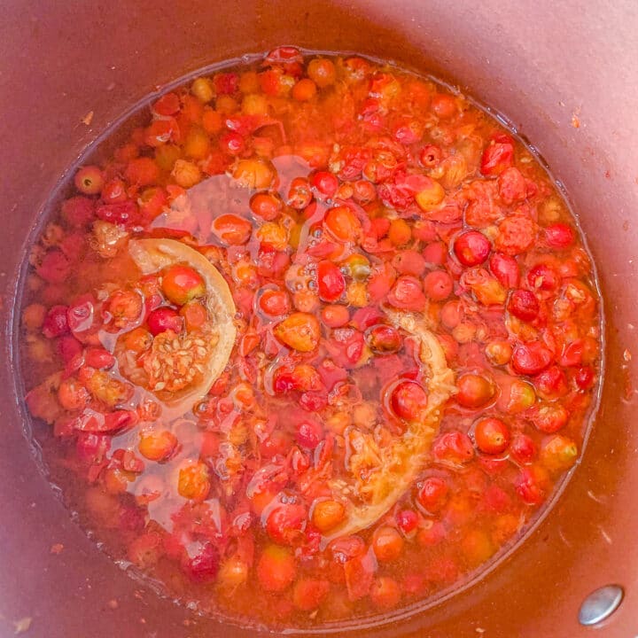 rose hips being simmered in a pot
