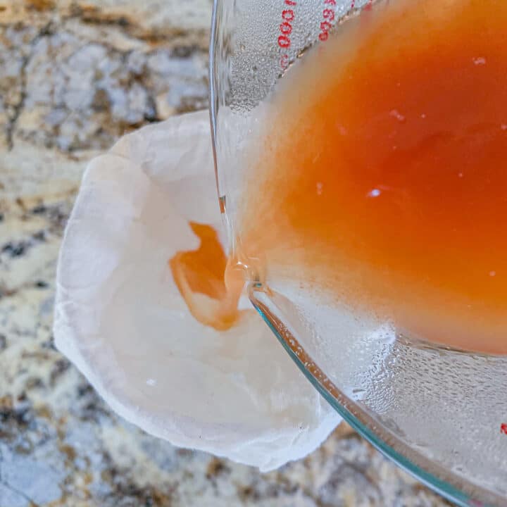 pouring juice through a soup bag to strain 