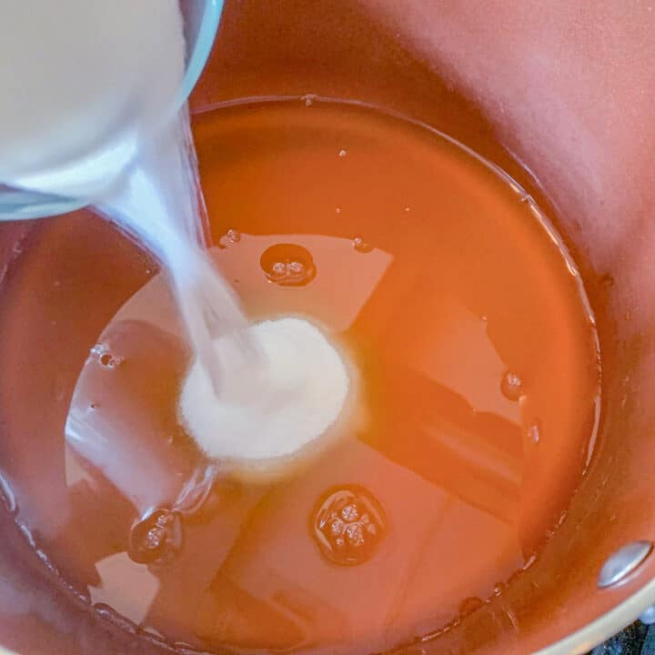 pouring sugar into liquid in a pot