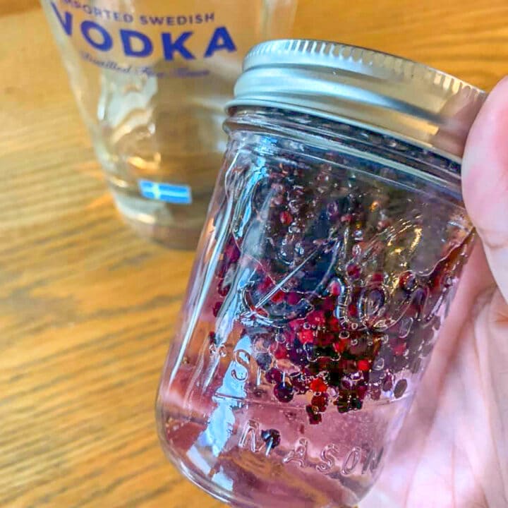 shaking elderberries mixed with vodka in a jar