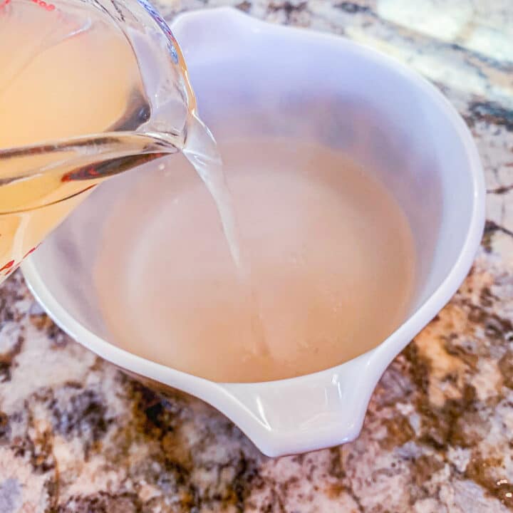 pouring vinegar into a bowl of water