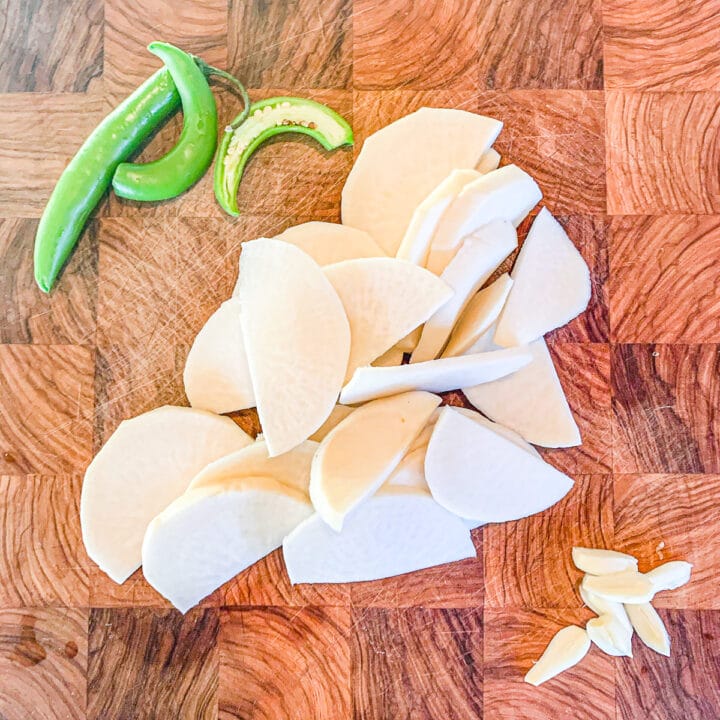 sliced turnips, sermons and garlic on a cutting board