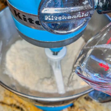 blue mixer with cake mix and oil being added