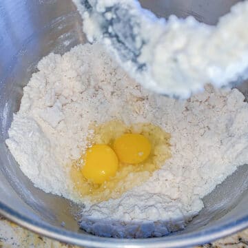 silver mixing bowl with flour and eggs