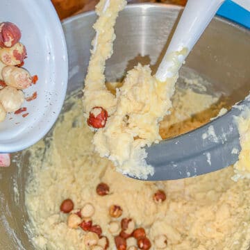 cake batter in a mixing bowl with nuts added