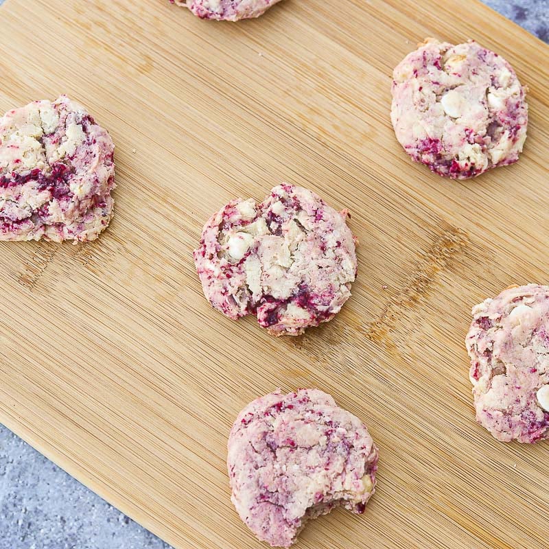 thimbleberry cookies on a cutting board, with a bite taken out of one of the cookies