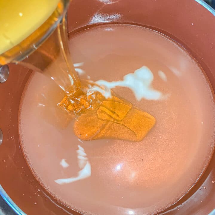 pouring honey in a pot of syrup