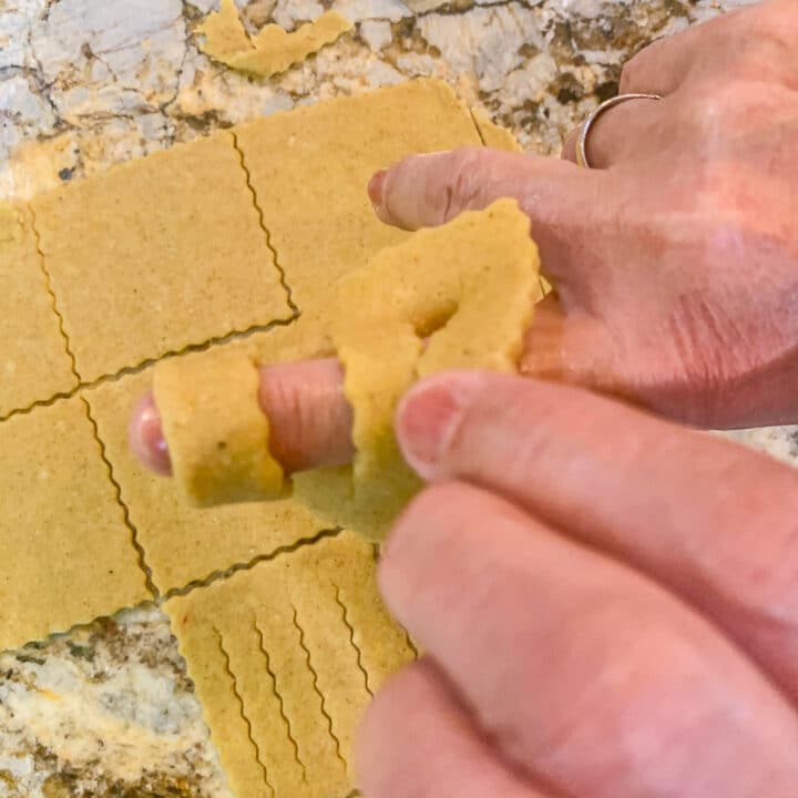 forming Chebakia dough over fingers to make cookies