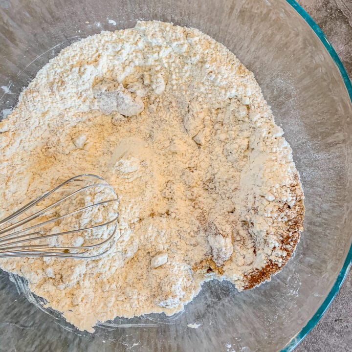 whisking flour, and spices in a glass bowl