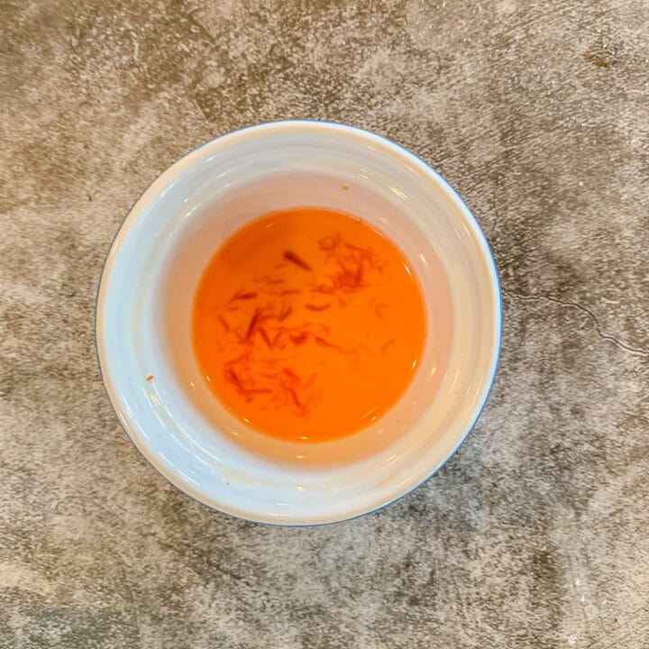 saffron threads in a small bowl of water