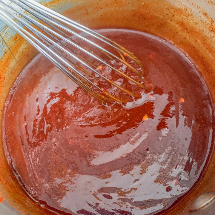 whisking bbq sauce in a small saucepan