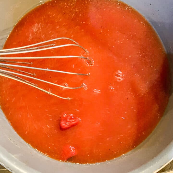 tomato sauce being whisked in a pot