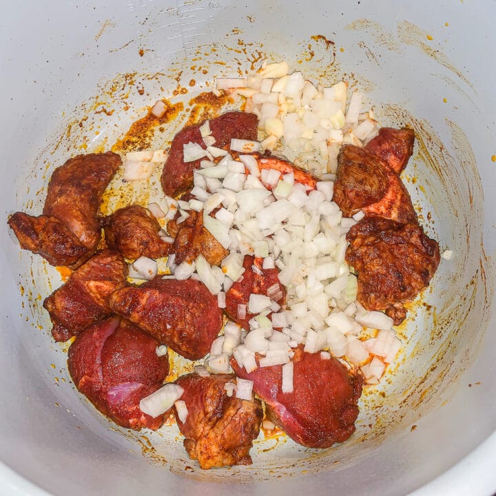 meat and diced onions being cooked in a pot