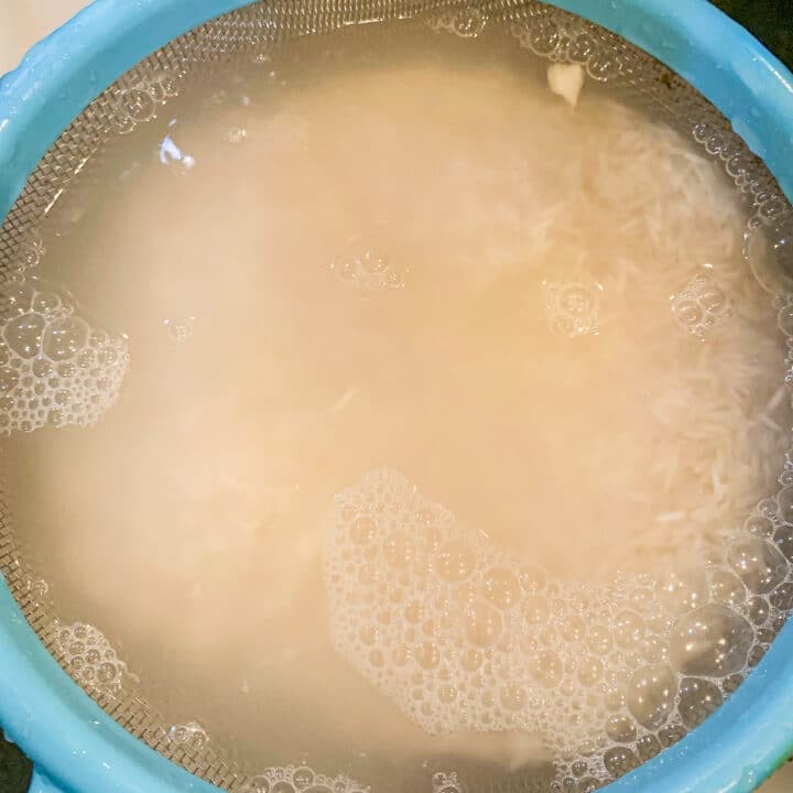 washing rice in a colander