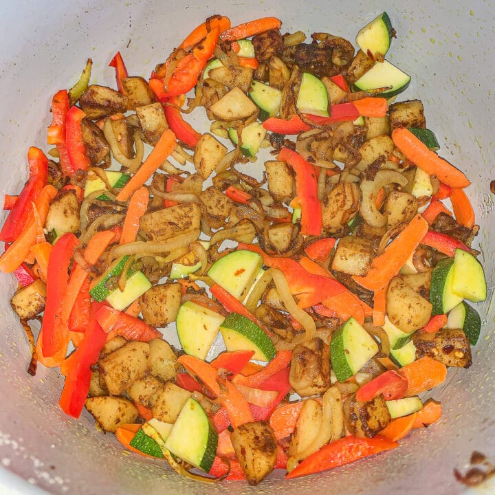 sliced and cubed vegetables being cooked in a pot