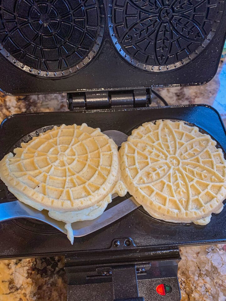 taking pizzelle off a pizzelle iron with a spatula