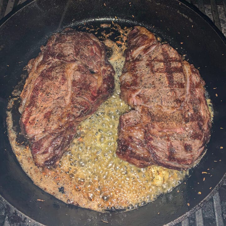 grilled ribeyes cooking in butter