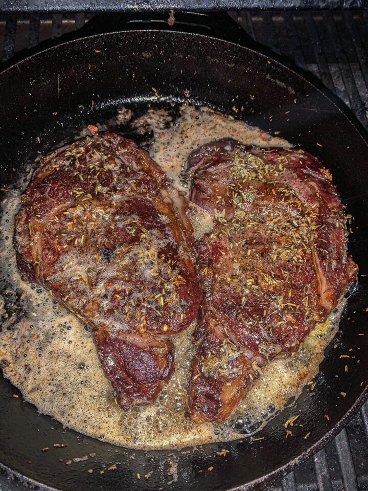 grilled ribeye steaks in a cast iron pan