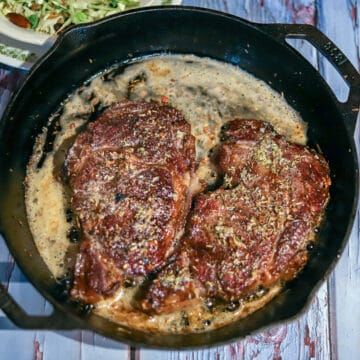 grilled ribeye steaks in a cast-iron skillet