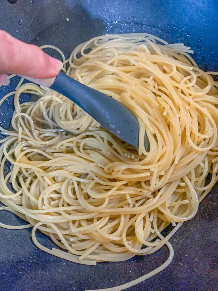 stirring pasta in a pan