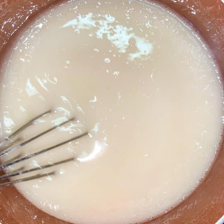 whisking white liquid in a pot