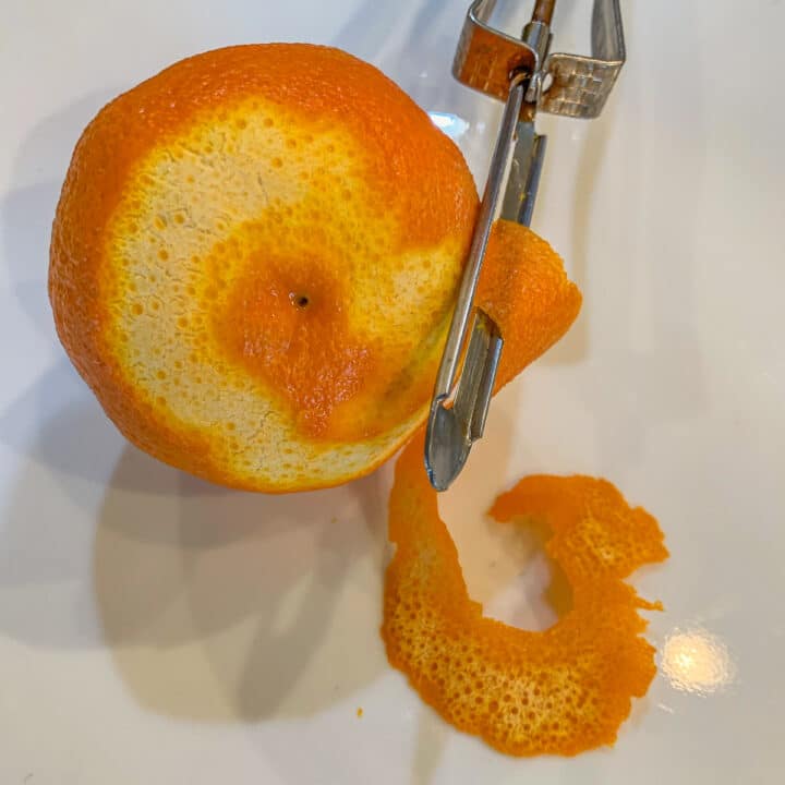 uma laranja sendo descascadas