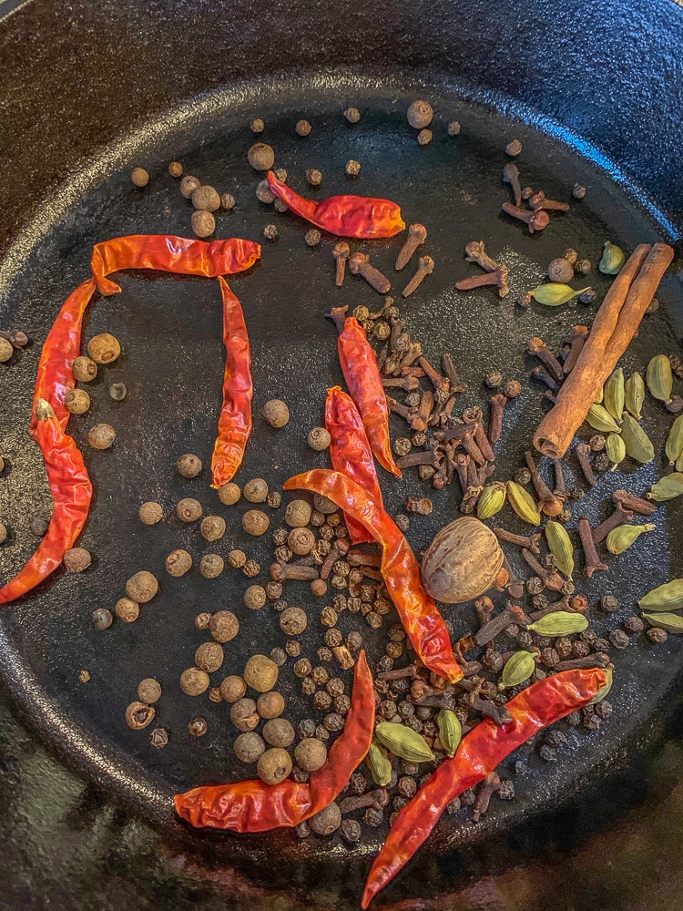 whole spices being toasted in a pan