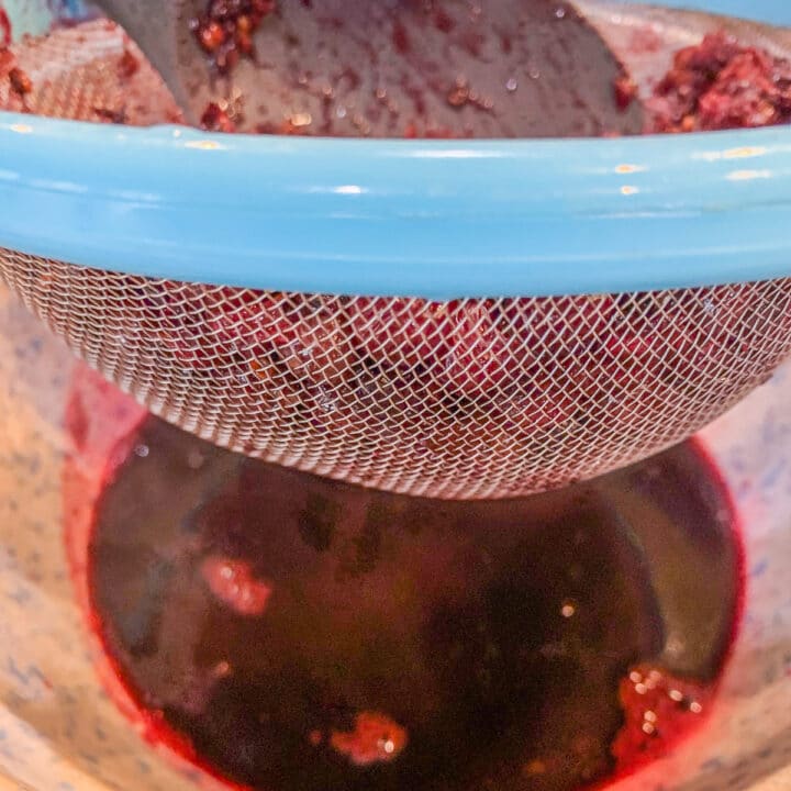straining berry juice in bowl