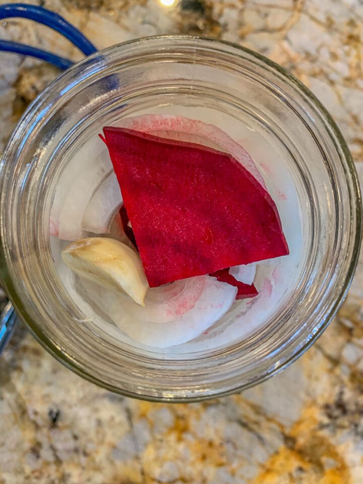 onions, beets, and garlic in a jar for pickling