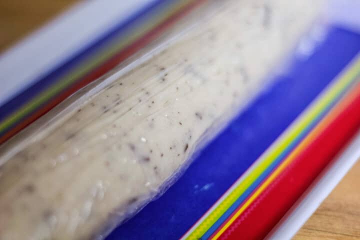 dough wrapped in plastic on a colorful plate