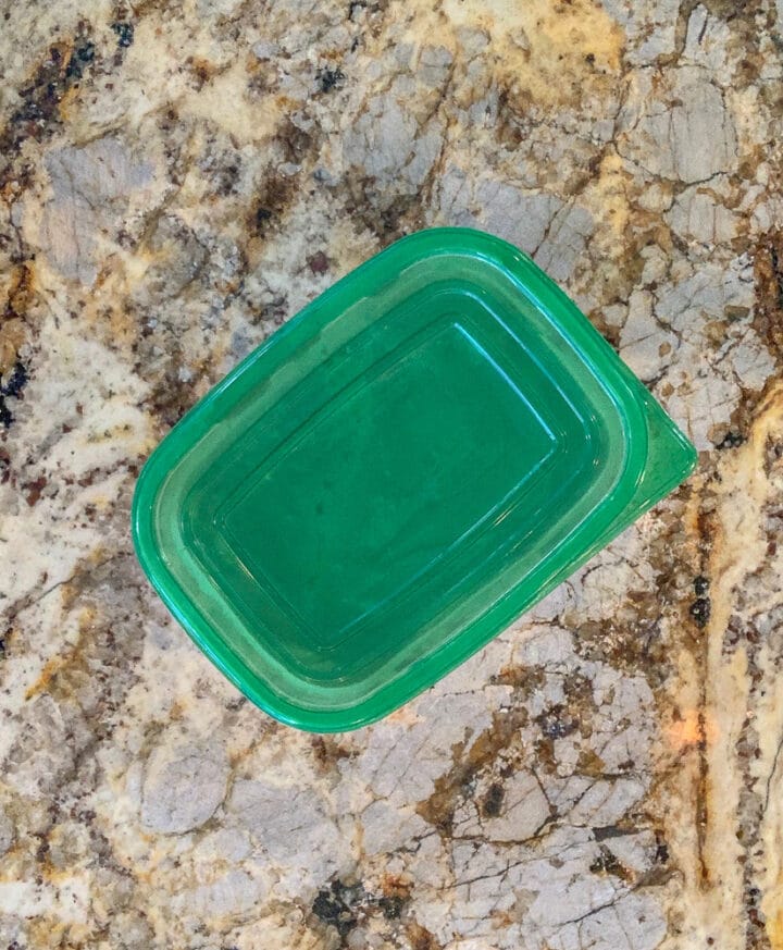 Tupperware with green lid on the counter