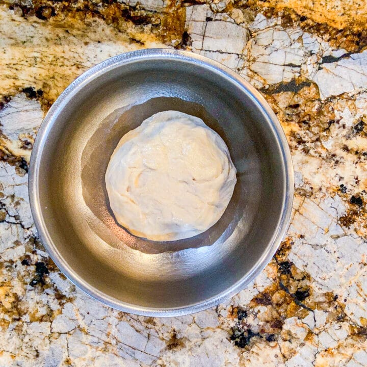 a silver bowl with a dough ball
